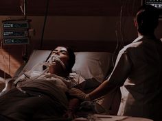 a woman laying in a hospital bed next to a man