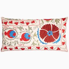 an embroidered pillow with red and blue flowers on it