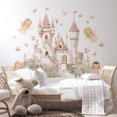 a teddy bear sitting in front of a princess castle wall mural with fairy figures on it