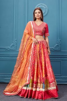 Red embroidered bandhej lehenga with a contrasting orange dupatta online in the USA. Featuring embroidered blouse with 3/4th sleeves blouse The Lehenga comes with a look royal at weddings and festive occasions in exquisite designer sarees, gowns, lehngas, Anarkali, and suits Pure Elegance Indian saree stores in the USA. Orange Anarkali With Bandhani Print, Orange Bollywood Choli With Bandhani Print, Red Bandhani Print Lehenga For Traditional Ceremonies, Orange Bandhani Print Traditional Wear For Festivals, Festive Orange Choli With Bandhani Print, Orange Banarasi Silk Choli With Dupatta, Orange Banarasi Silk Lehenga With Dupatta, Orange Banarasi Silk Choli For Navratri, Orange Bandhani Print Sharara For Festive Occasions