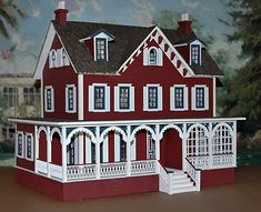 a paper model of a red house with white balconies on the front porch