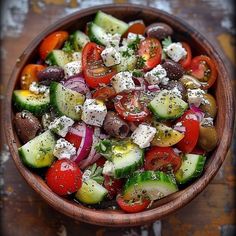 a wooden bowl filled with lots of different types of vegetables