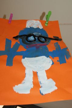 a child's drawing of a blue man with glasses on an orange paper bag