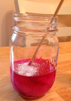 a glass jar filled with liquid on top of a wooden table