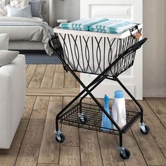 a black and white shopping cart with blue towels on the top in a living room