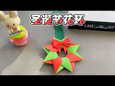 an origami star decoration next to a small box with a bunny on it