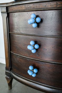 an old dresser has blue knobs on it