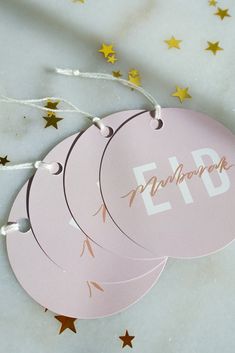 three pink tags with gold stars on them that say eid and the word eid