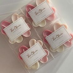 four square shaped candles with pink and white petals