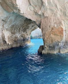 an ocean cave with blue water and large rocks