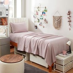 a bed with pink sheets and pillows in a room