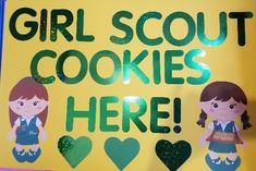 a sign that says girl scout cookies here with two girls on it and hearts in the background