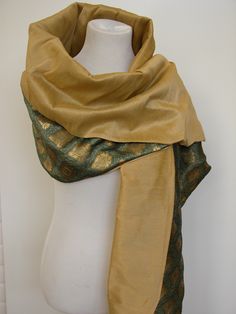 Our Beyond Luxury Wrap is truly couture. Two sided shawl made of 100% silk with a twist. A Go Kismet Original which I found in Italy and then reproduced as an affordable option. One side of the shawl is made of raw silk. Raw silk has a depth to it which most fabrics do not. Formidable and textured. Light is captured and plays off the natural threads. One size fits most.The reverse side of the shawl is made of silk damask. Each panel has been woven with gold or silver threads creating an engineer Formal Festive Silk Shawl, Traditional Silk Scarves For Formal Occasions, Elegant Silk Mark Certified Silk Dupatta, Traditional Gold Silk Scarves, Silk Shawl Scarf, Traditional Drape Gold Silk Shawl, Elegant Tussar Silk Pashmina Shawl, Traditional Gold Silk Scarf, Gold Silk Dupatta, Silk Mark Certified