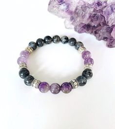 "Amethyst and Labradorite Bracelet, Amethyst Bracelet, Labradorite Bracelet, Gemstone Bracelet This lilac purple and dark gray bracelet is an eye-catching unique gemstone combination that is complimented with antique silver Tibetan spacer beads. 8mm Amethyst and Labradorite are strung on a strong stretch cord for a comfortable fit for your wrist.  The calming stone of amethyst is a natural stress reliever and is said to promote balance, peacefulness, contentment, and happiness. This semi-precious stone is known to calm and soothe the mind and emotions. Wearing an amethyst bracelet is a great way to carry the calming energy around with you wherever you go. Labradorite is known as the \"stone of transformation\" is said to help those seeking knowledge and guidance to find answers. It is exce Lavender 8mm Beads Jewelry For Healing, Lavender Spiritual Jewelry With 8mm Beads, Spiritual Lavender Jewelry With 8mm Beads, Lavender 8mm Beads Bracelet Gift, Lavender Spiritual Jewelry With Beads, Spiritual Lavender Bracelets With Natural Stones, Lavender Hand-strung Spiritual Bracelets, Lavender Natural Stones Spiritual Bracelet, Lavender Hand-strung Spiritual Bracelet