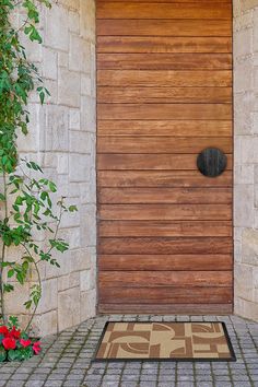 a wooden door with a decorative mat on the floor