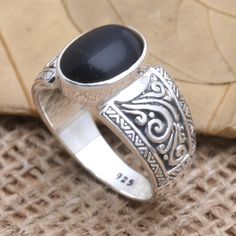 A jet black gem commands attention at the center of Made Mustika's stunning cocktail ring. The Balinese artisan crafts the ring from a smooth onyx stone in a sterling silver bezel setting engraving the ring's sterling silver band with fascinating oxidized designs. Black Sterling Silver Jewelry With Oval Cabochon, Black Oval Cabochon Sterling Silver Jewelry, Black Oval Cabochon Jewelry For Anniversary, Black Cabochon Ring As A Gift, Black Cabochon Ring For Gift, Black Sterling Silver Open Ring Jewelry, Black Sterling Silver Cabochon Ring, Silver Onyx Cabochon Rings, Black Cabochon Sterling Silver Ring