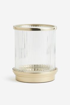 a clear glass and brass candle holder