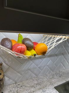 a hammock filled with fruit sitting on top of a kitchen counter