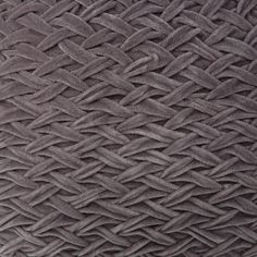 close up view of the texture of a gray blanket with braiding on it's sides