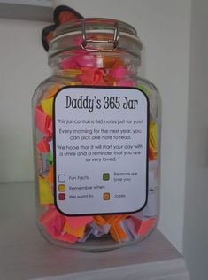 a glass jar filled with lots of colorful confetti and paper clips on top of a counter