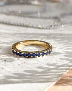 The Audrey Ring has all the royal blue vibes. Perfect for stacking with other rings in your collection or for a simple chic look. This ring is 18k gold plated silver with cubic zirconia stones. This is for one ring. Ring sizes: 6,7,8 Elegant Yellow Gold Sapphire Eternity Band, Blue Gold-plated Rings For Gifts, Gold Plated Blue Rings As Gift, Blue Gold Plated Rings As Gift, Blue Gold Plated Rings For Gift, Gold Sapphire Eternity Band With Prong Setting, Timeless Gold Sapphire Ring, Classic Stackable Sapphire Rings In Yellow Gold, Classic Blue Stackable Jewelry