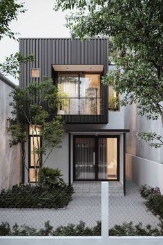 the house is surrounded by trees and bushes, with black metal cladding on the windows