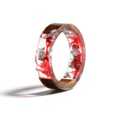 a red and white ring with some diamonds on the inside, in front of a white background