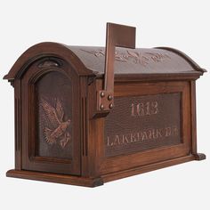 a wooden mailbox with an eagle emblem on the front and side panel is shown