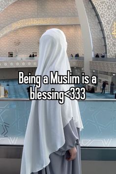 a woman wearing a white veil standing in front of a building with the words being a muslim