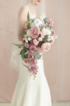 a woman in a wedding dress holding a bouquet of flowers