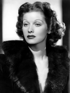 an old black and white photo of a woman wearing a fur coat with her eyes closed