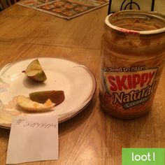 a jar of pickles sitting on top of a wooden table next to a plate