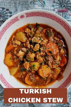 a white bowl filled with chicken stew on top of a blue and pink table cloth