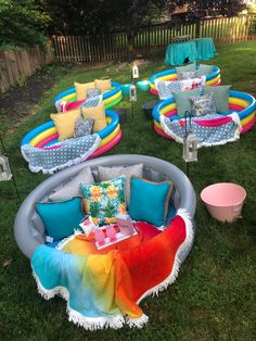 an inflatable pool with lots of pillows and blankets on it, surrounded by lawn furniture