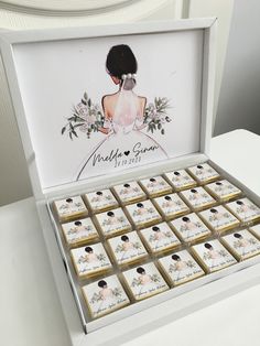 a box filled with lots of cookies on top of a white table next to a chair