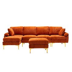 an orange couch and ottoman with gold legs