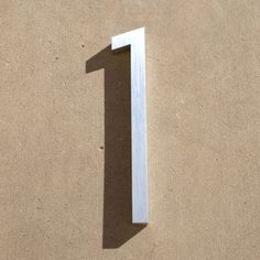 the number one is made out of white plywood and has a shadow on it