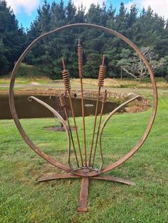 a metal sculpture in the shape of a circle with four arrows sticking out of it