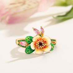 Pear blossoms traditionally represent purity, love, and longevity in Chinese culture and are also considered one of the most beautiful flowers when they are kissed with raindrops, sometimes used to describe attractive women, further promoting the flower's feminine nature. The ring features pear blossoms and leaves that wrap around your finger, detailed with bright enamel for lovers of colour! The perfect accessory for spring and summertime, or to keep the floral vibe going all year round.Carat W Flower Shaped Birthstone Ring, Flower-shaped Wedding Rings For Spring, Spring Flower Jewelry For Anniversary, Spring Wedding Flower Ring, Flower Shaped Birthstone Promise Ring, Mother's Day Green Flower Jewelry, Flower Shaped Ring For Wedding And Mother's Day, Blossom Flower-shaped Jewelry For Anniversary, White Flower Ring For Promise