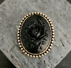 Detailed black on black rose cameo set in antique brass with a locking pinback. Details: *Measures approx 2.25 x 2 inches *Secure, locking pin back  *Cameo is made of a hard, matte resin *Setting is plated brass Matching locket shown in the last photo is available here: https://www.etsy.com/listing/463033286/mourning-cameo-locket-black-rose-cameo?ga_search_query=black+rose&ref=shop_items_search_7 Thank you for shopping Delicate Industry :) Gothic Brooch, Cameo Locket, Marine City, Gift Ideas For Mom, Unique Christmas Gift, Holiday Gift Ideas, Cameo Brooch, Unique Christmas Gifts, Pin Backs