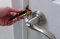 a person is opening a door with a key in their left hand and holding the handle