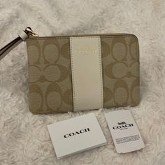 New Coach Wristlet. Gold Tone Hardware, Attached Wrist Strap. Color Is Light Khaki (Body) And Chalk (Center Stripe/Wrist Strap) 6.25”(L) X 4”(H) X 0.5” (W) Interior Pockets For Credit Cards. Beige Clutch With Wrist Strap For Gift, Beige Clutch With Wrist Strap As Gift, Chic Beige Bags With Wrist Strap, Beige Coach Pouch Wristlet, Coach Beige Pouch Wristlet, Elegant Beige Wallet With Zipper Pouch, Elegant Beige Wallets With Zipper Pouch, Beige Zipper Closure Wristlet Clutch, Beige Wristlet Clutch With Zipper Closure