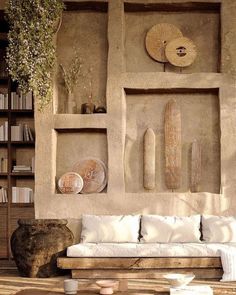 a living room filled with furniture and bookshelves next to a wall covered in stone