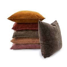 four pillows stacked on top of each other in different colors and sizes, one is brown