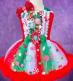 a red and green dress with candy canes, lollipops, peppermints, candies, and more on it