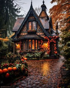 a house with pumpkins on the ground and trees in front of it at night