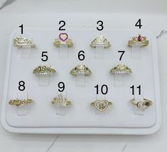 an assortment of rings are displayed on a white display tray with numbers and symbols in the middle