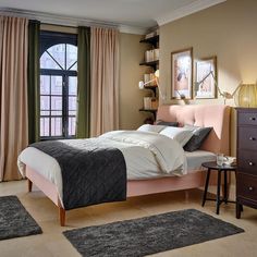 a bedroom with a bed, dresser and window in the corner that has curtains on both sides