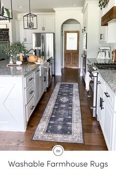 a kitchen with an area rug on the floor and white cabinets in front of it