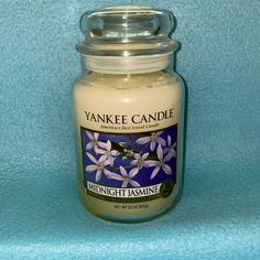 a yankee candle is sitting on a blue background with the words midnight fawnine